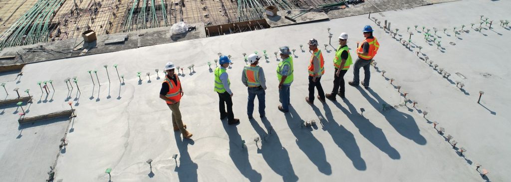 seven construction workers standing on white field